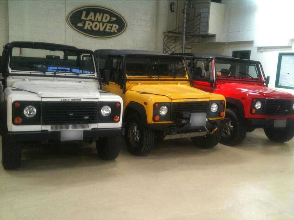 Three Land Rover Defenders in a showroom